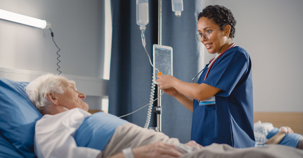 Nurse treating patient in hospital bed