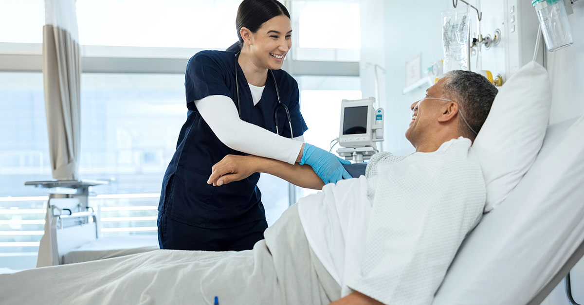 Nurse tending to patient in hospital bed